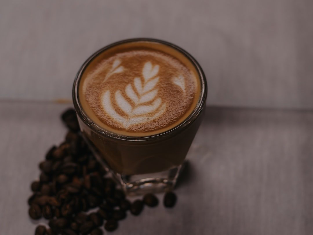 A steaming cup of coffee sits on a rustic wooden table, highlighting the essence of Coffee Culture Redwood's artisanal approach.