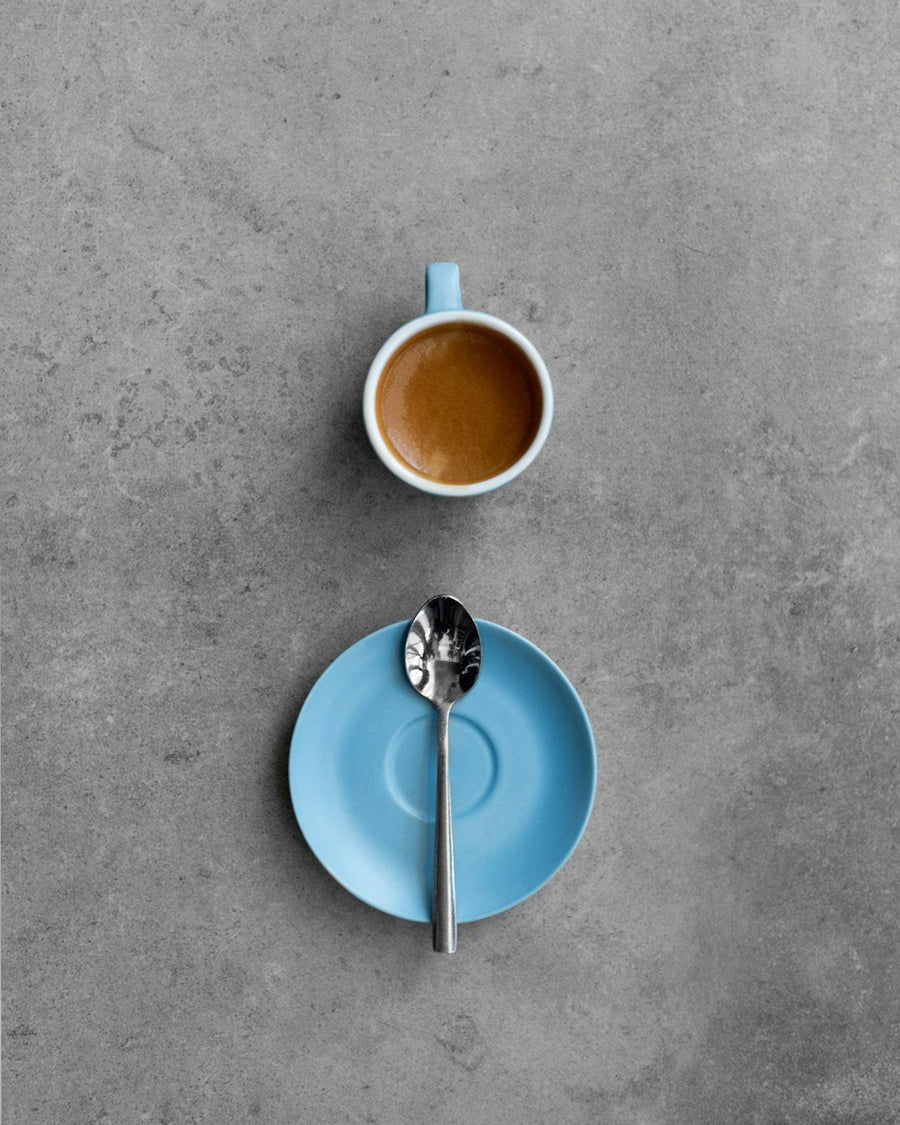 A barista serving cappuccino in a busy Italian café, highlighting the cultural norm of avoiding cappuccino after 11am.