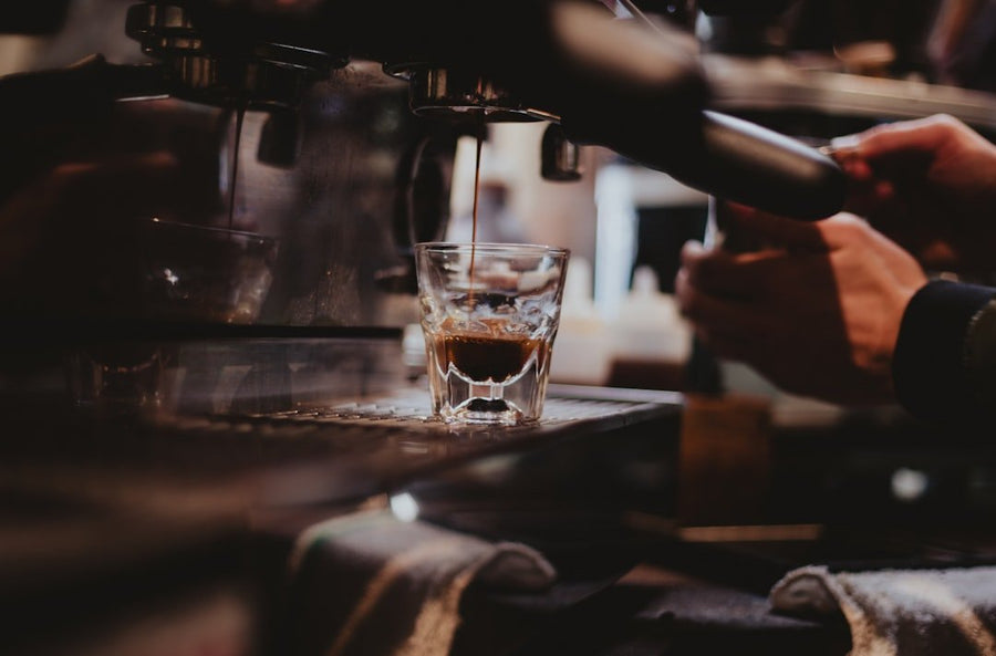 A vibrant brunch drink featuring espresso, orange juice, and a frothy topping, perfect for pairing with granola.