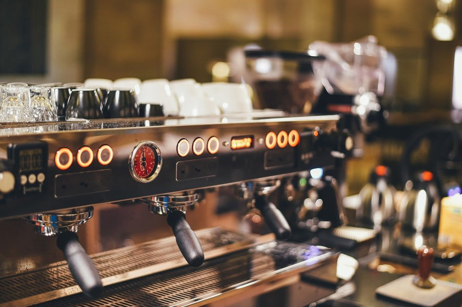 A barista adjusts an espresso machine's settings, showcasing precise techniques to dial in espresso without wasting coffee beans.