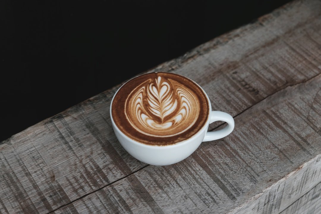 A barista expertly prepares a flat white, showcasing its velvety microfoam and rich espresso, symbolizing its global coffee trend.