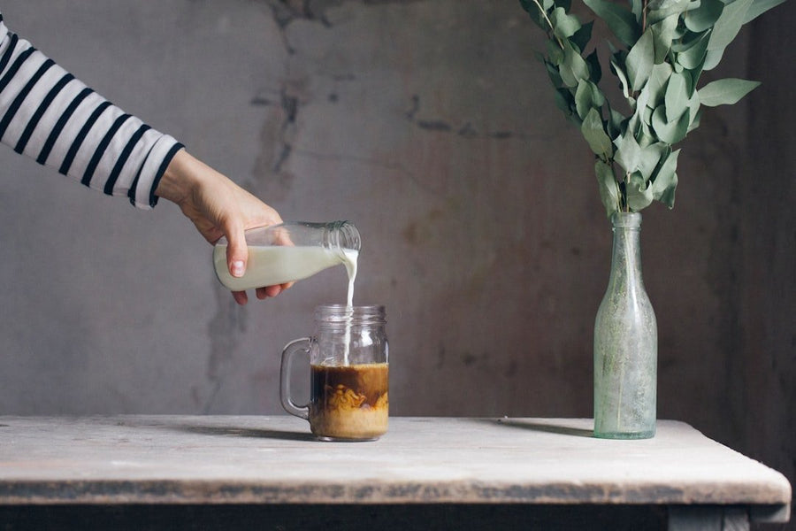 Iced caffe americano in a glass beside cold brew coffee, highlighting differences in color and texture for comparison.