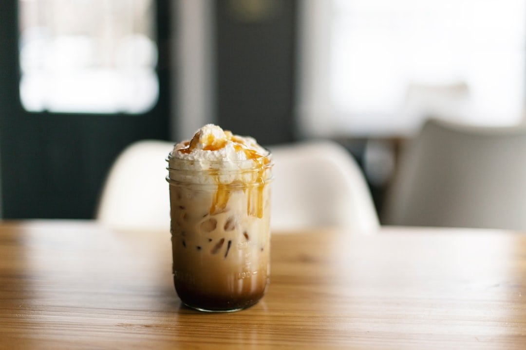 Two glasses side by side: one filled with creamy iced coffee and the other with a dark iced Americano, showcasing summer beverage options.
