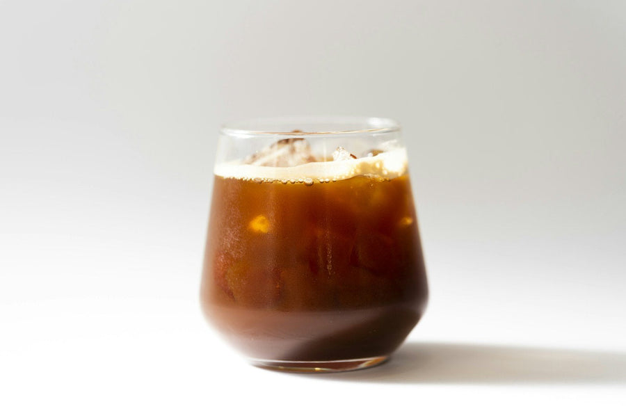 A glass of caffè freddo: chilled espresso over ice with a light layer of foam.