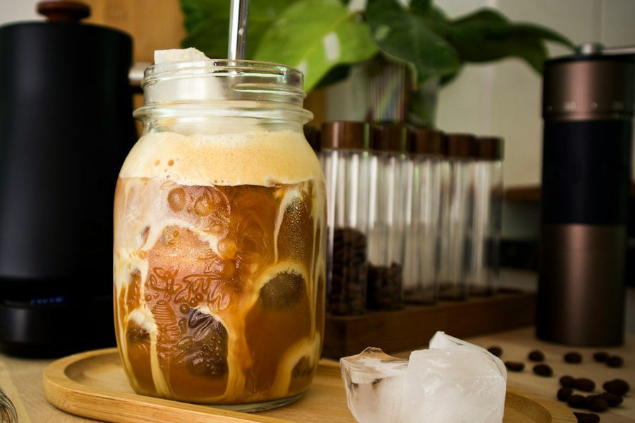 A frothy fredo kapucino sits on a table, showcasing Greece's unique iced espresso culture with rich coffee and creamy foam.