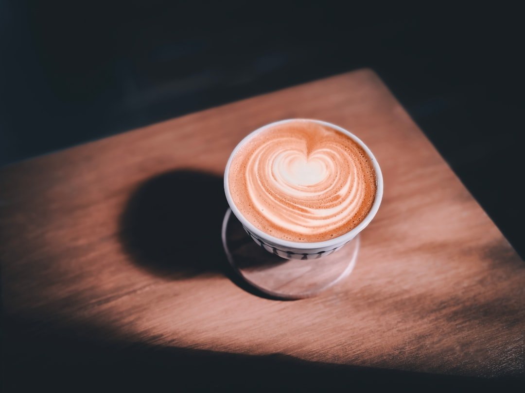 A barista expertly prepares a flat white, showcasing its velvety microfoam and rich espresso, highlighting its rise in coffee culture.