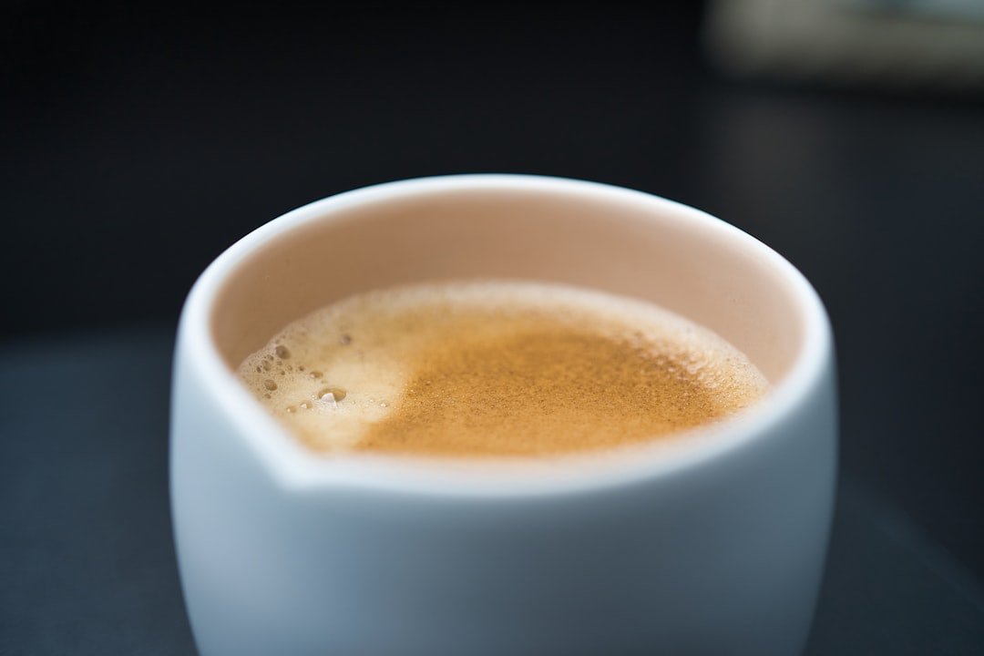 Close-up of a rich, golden crema atop a freshly brewed espresso shot, illustrating the science behind espresso extraction.