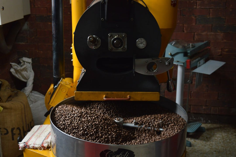 Small batch roasting process showcasing equipment and freshly roasted coffee beans, emphasizing reduced waste and sustainable practices.