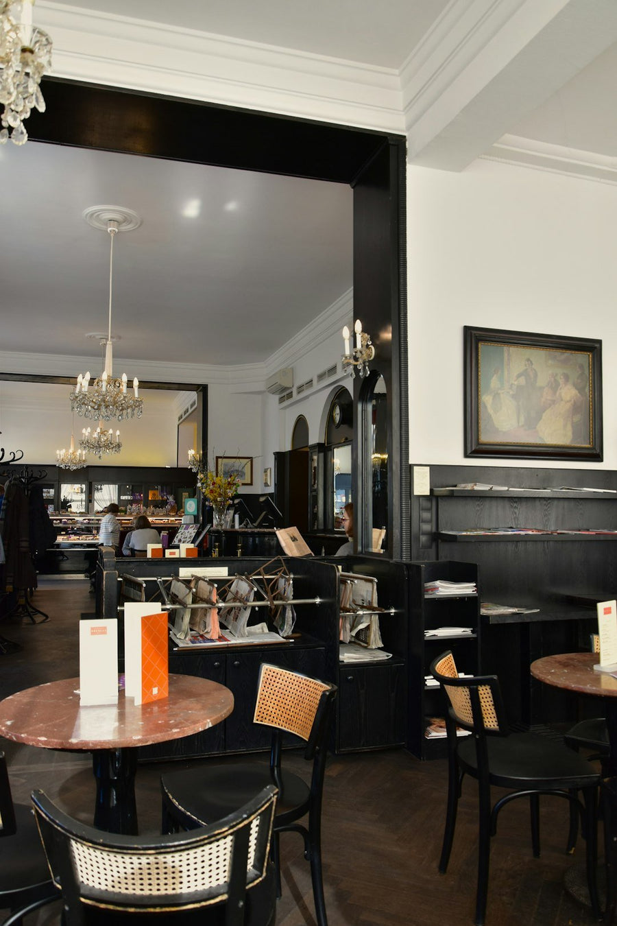 A bustling Viennese coffee house filled with patrons enjoying coffee, pastries, and conversation, highlighting the cultural significance of this tradition.
