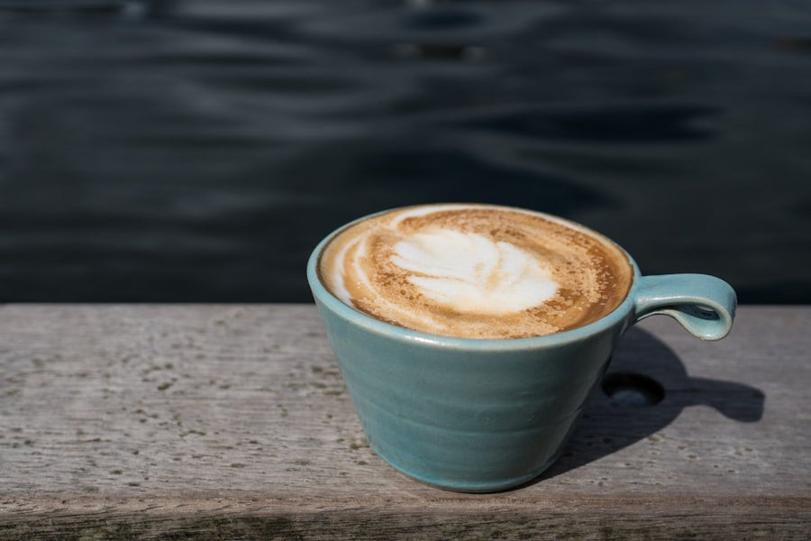 A refreshing Freddo Cappuccino, showcasing layers of frothy milk and rich espresso, served over ice in a clear glass.