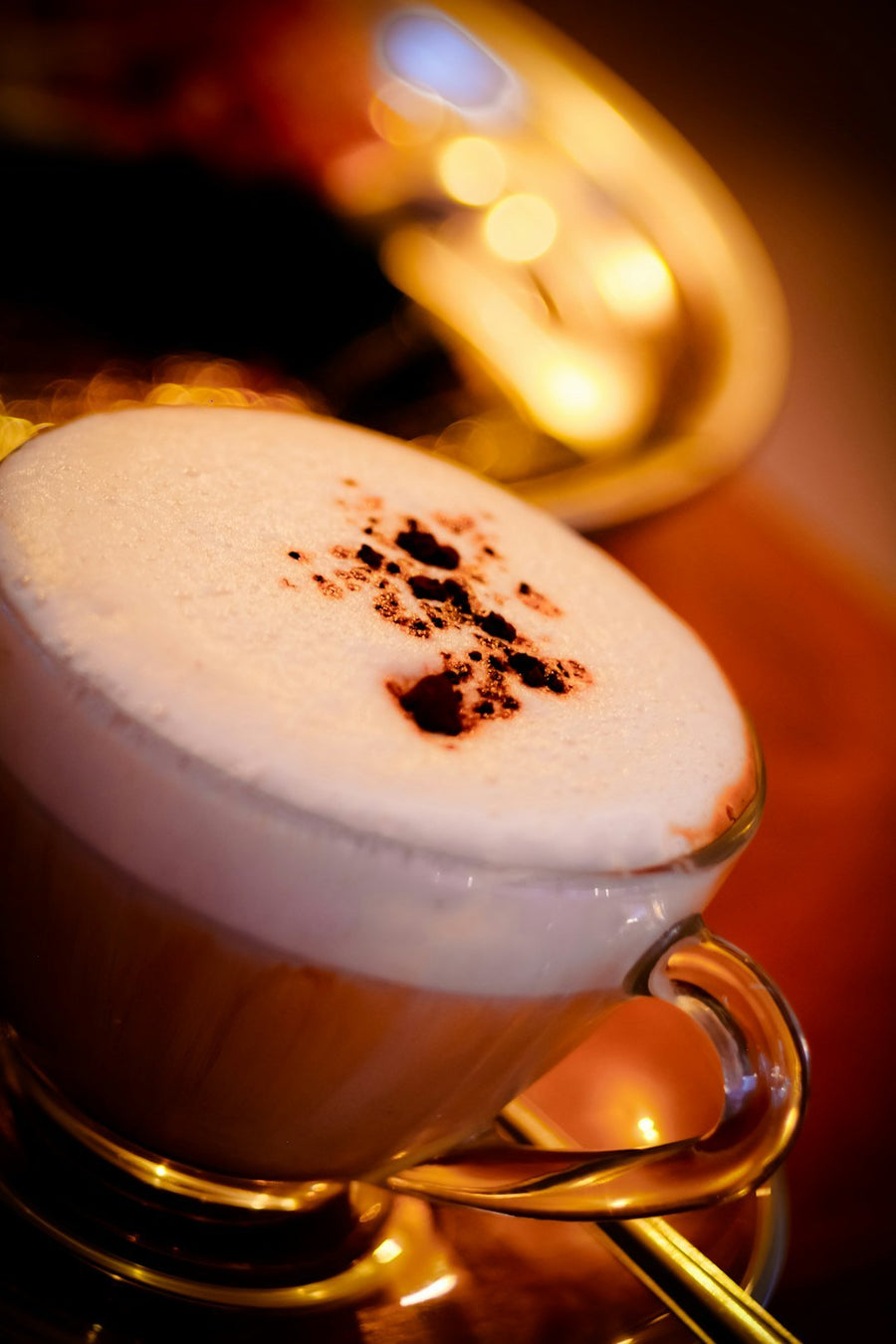 A frothy Freddo Cappuccino served in a clear glass, showcasing layers of espresso and milk foam, highlighting its Greek origins.