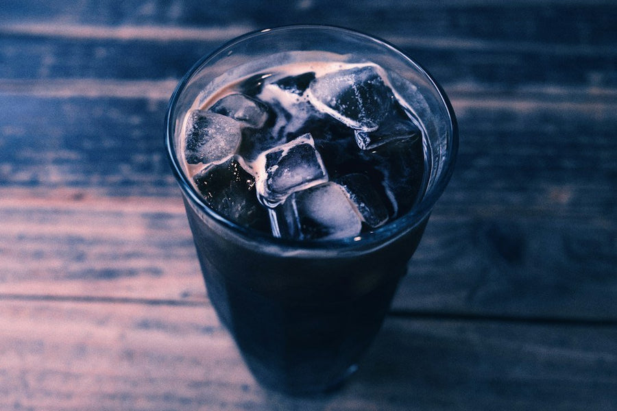 A refreshing Iced Americano coffee served in a clear glass, showcasing rich espresso and chilled water, highlighting its simplicity and flavor.