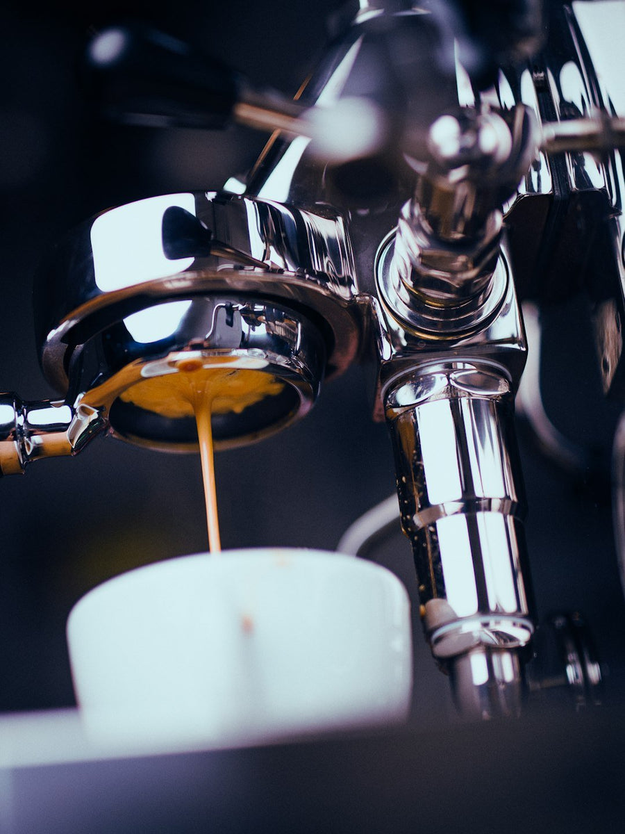 A steaming cup of caffe americano sits on a wooden table, showcasing its rich, dark color and inviting aroma.