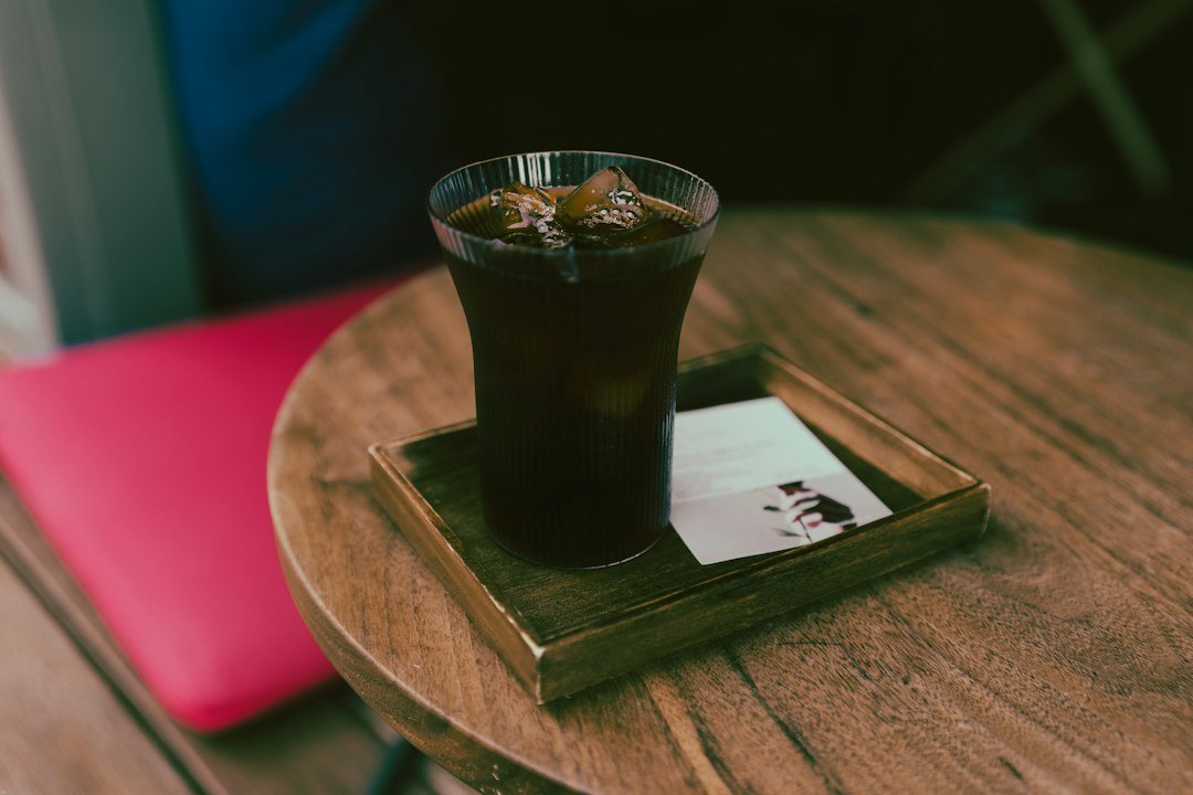 A refreshing iced Americano coffee in a reusable glass, highlighting sustainable ordering practices for eco-conscious consumers.