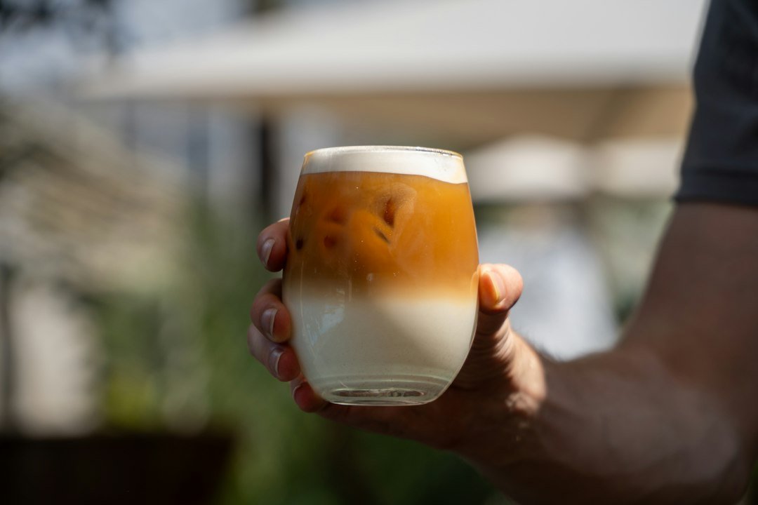 A refreshing iced latte in a clear glass, showcasing layers of espresso, milk, and ice, symbolizing its popularity in coffee culture.